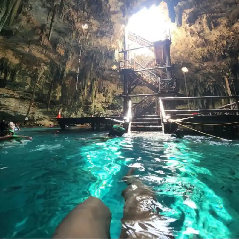 Chaksikín semi-open cenote with limestone vault, roots and turquoise water at Santa Bárbara