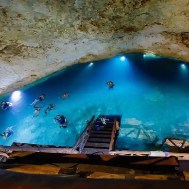 Cascabel cave cenote with clear blue water and illuminated cavern at Santa Bárbara